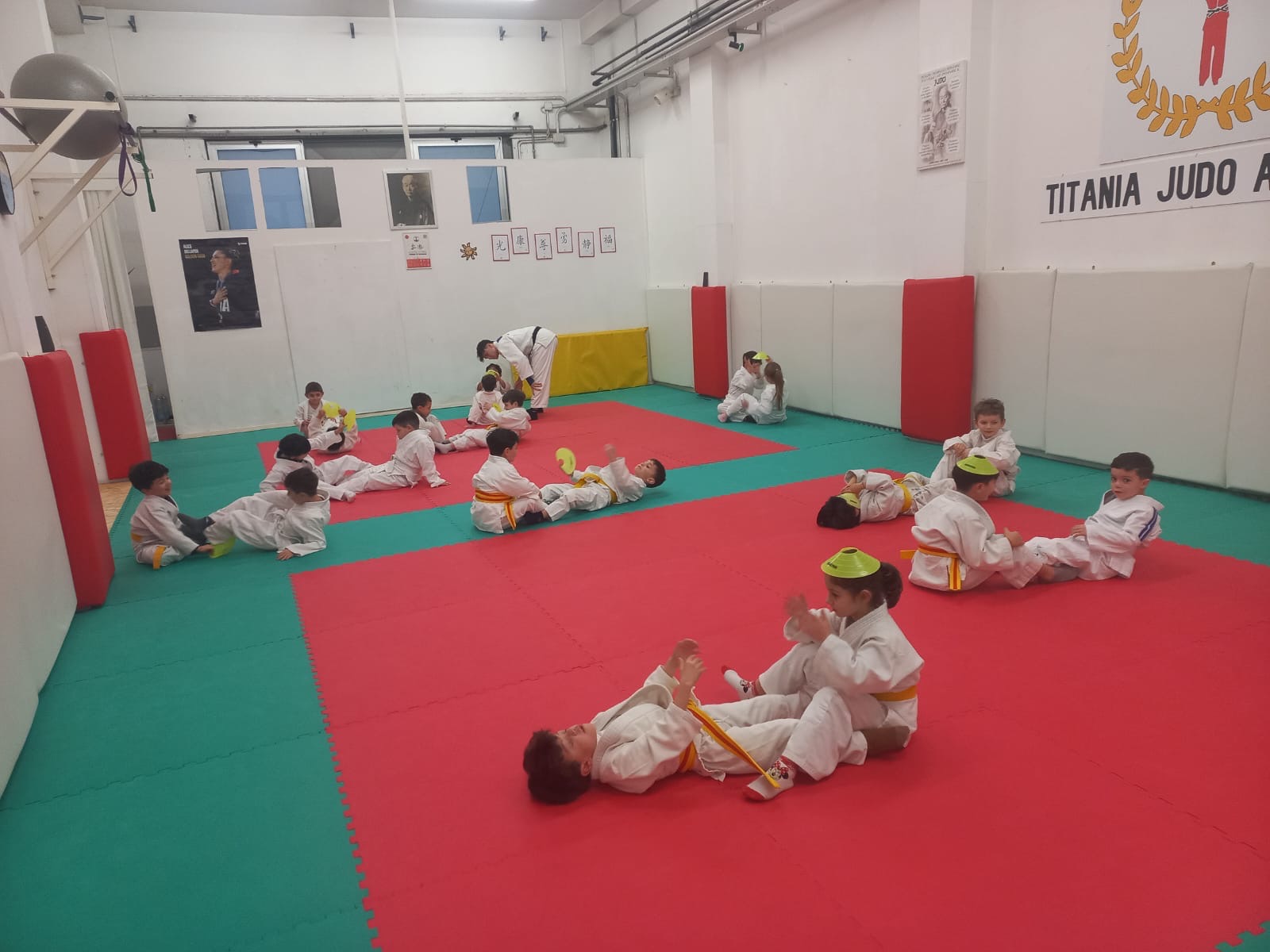 Bambini in judogi che giocano con i coni sul tatami